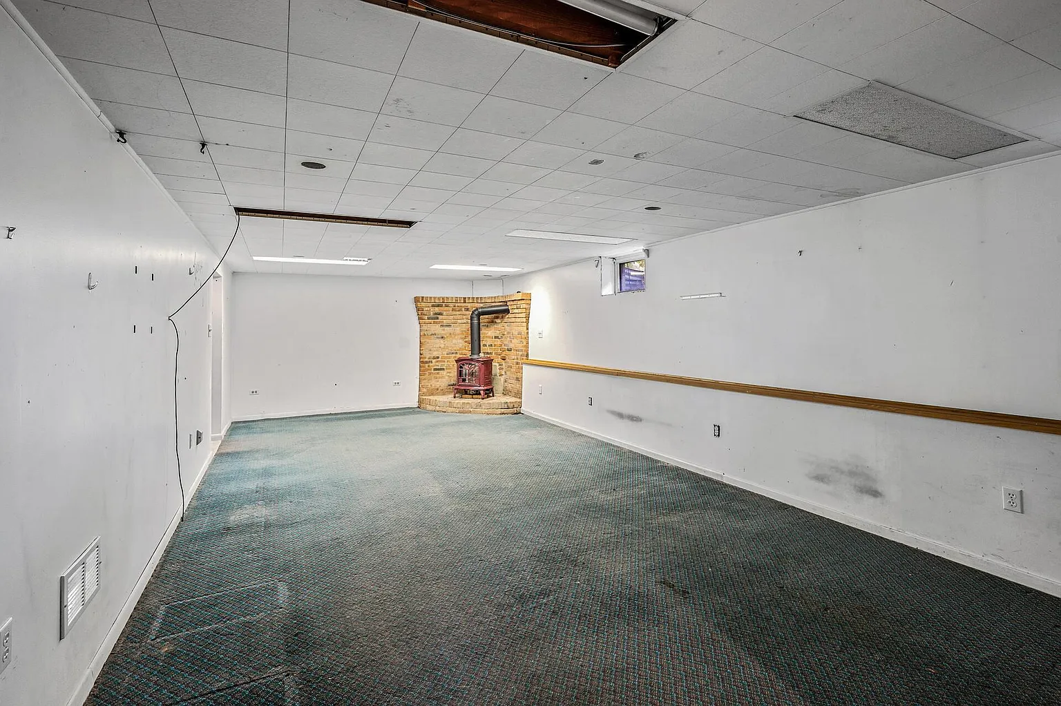 Private room with windows, ceiling fan, and green carpet